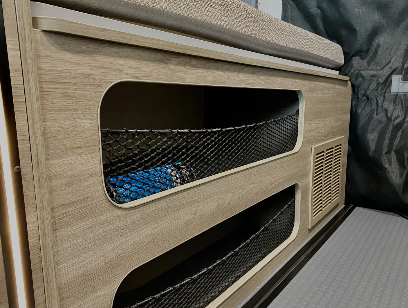 Convenient storage nets in this modern rv rental's side panel, perfect for keeping items secure.