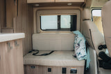 RV rental interior: Cozy dinette with bench seating, window, and power outlets for a comfortable travel experience.