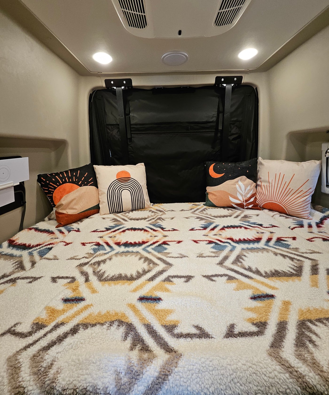 Comfortable RV rental bed with stylish desert-themed pillows & a warm, textured geometric blanket for cozy travels. — photo 4