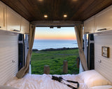 Wake up to amazing coastal views from this cozy rv rental. Perfect for van life, this camper features a comfy bed & ocean sunsets.