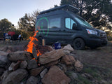 Cozy camping night with a roaring campfire next to an adventure rv rental van. Perfect for outdoor getaways.