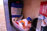 RV rental storage: camping gear, including a water jug, paper towels, kitchen supplies, and a box for a classic stove.