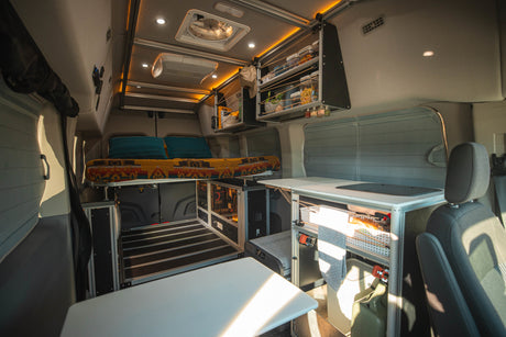 Cozy & fully-equipped rv rental interior with bed, kitchen, storage, and power system for comfortable travels.