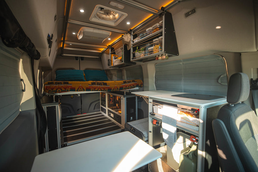 Cozy & fully-equipped rv rental interior with bed, kitchen, storage, and power system for comfortable travels.