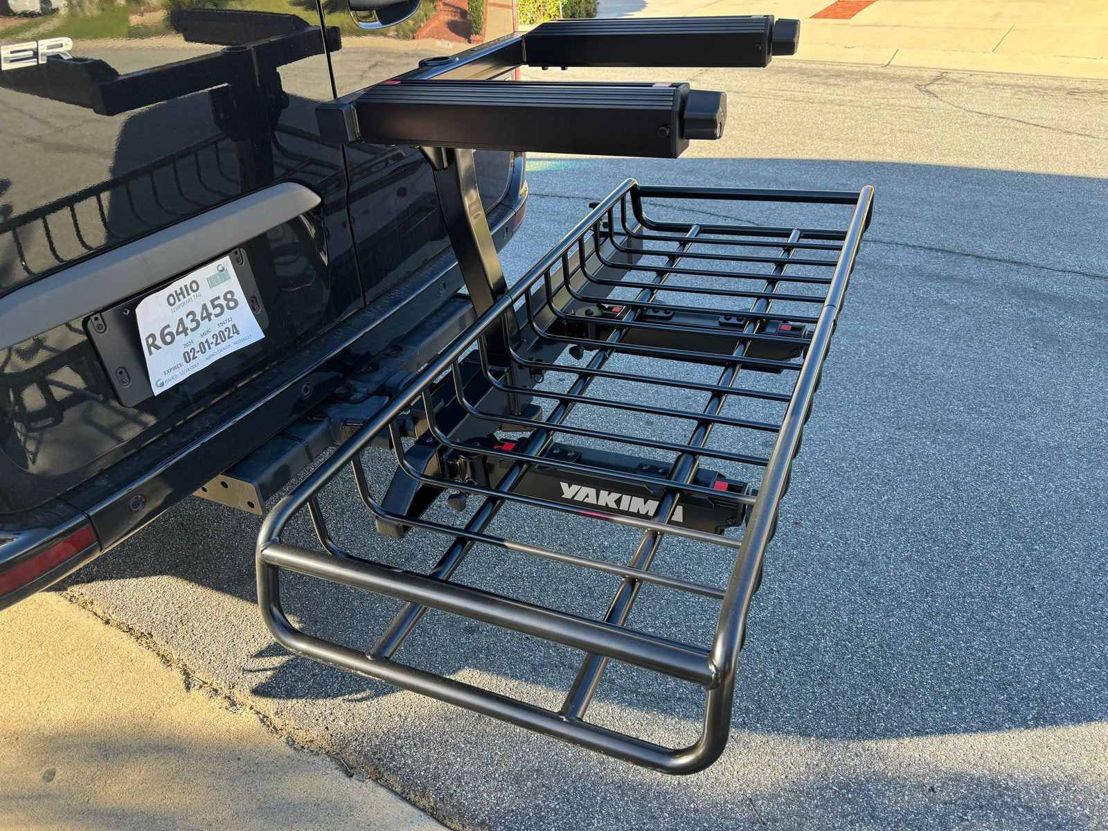 Vehicle with Ohio temporary tag, featuring a Yakima hitch cargo carrier and upper gear racks, ideal for an rv rental.