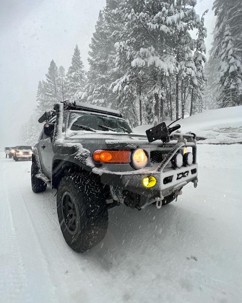  distorted lights from raindrops on an RV rental window at night.|Gray modified FJ Cruiser with rooftop tent on sandy beach at sunset. Ideal for adventure travel; consider this like an RV rental!|Adventure-ready off-road vehicle with rooftop tent in a rocky mountain landscape — photo 1