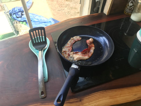 RV rental cooking: Sizzling bacon on an induction cooktop in an RV kitchen. Enjoying breakfast on the road!
