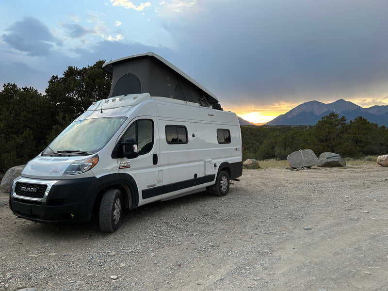 White pop-top RV rental on gravel — photo 1