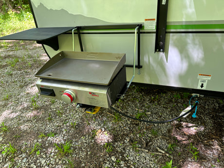 This RV rental features a convenient side-mounted griddle, ideal for outdoor cooking and camping.