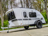 Sleek white Luna Rover teardrop travel trailer with a roof rack & rugged tires, ready for your next rv rental adventure.