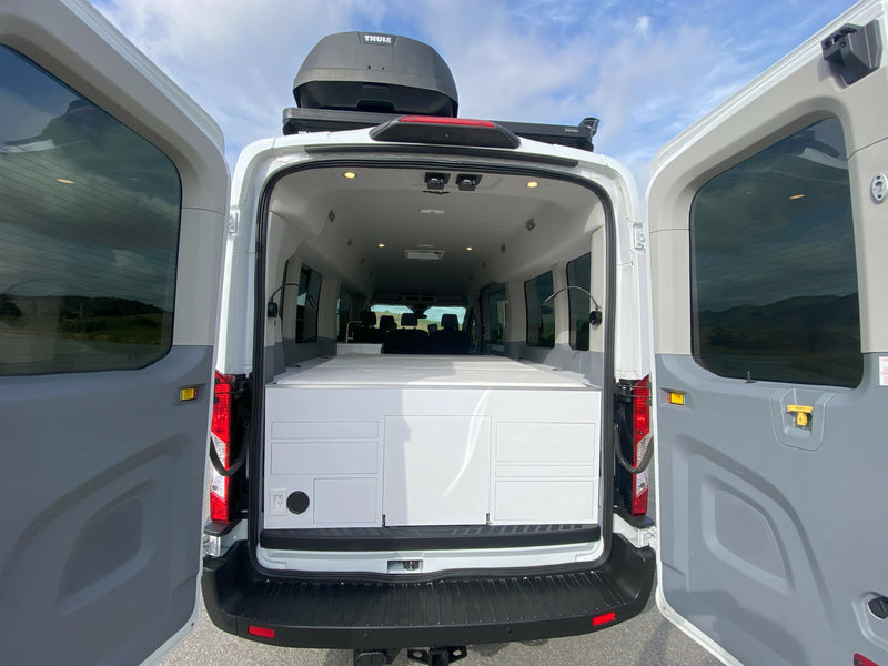 RV rental camper van. Rear doors open revealing custom interior, storage/bed unit, and Thule roof box. — photo 3