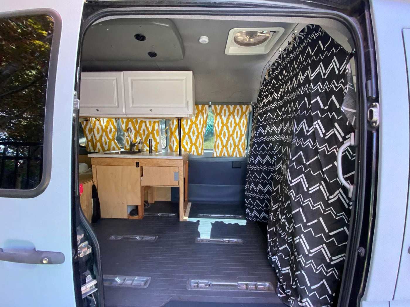  perfect for an RV rental adventure.|Inside this cozy RV rental: a modern van conversion with a kitchenette