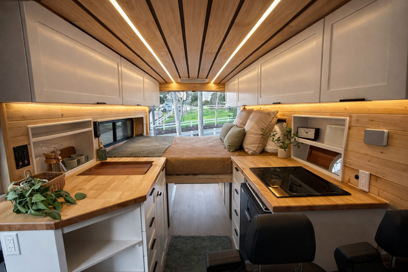 Cozy camper van interior with kitchen, bed, and stylish wood accents, perfect for an RV rental adventure.