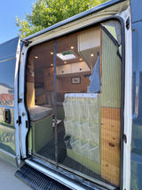Step into this cozy RV rental camper van, featuring a custom wooden interior, mesh screen door, and built-in storage.