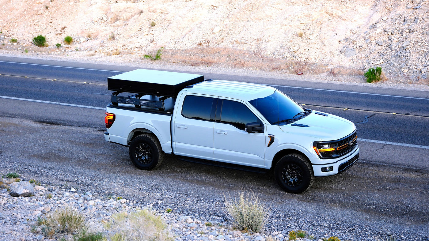 White Ford F-150 pickup, equipped with a hardshell rooftop tent, ready for an RV rental camping trip in the desert. — photo 12