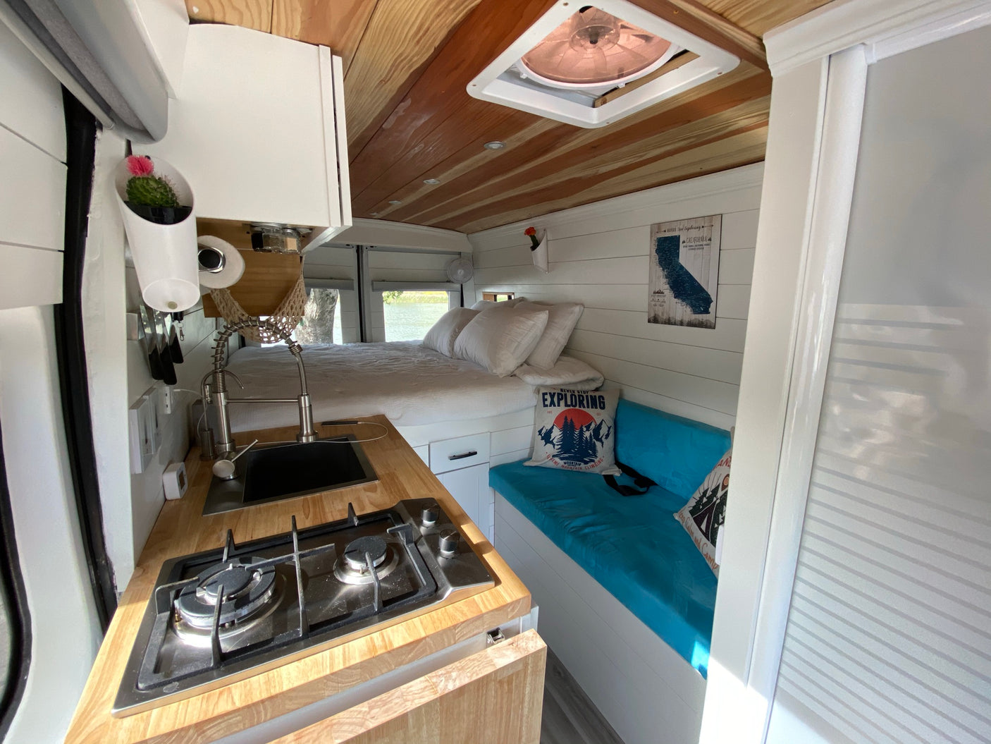 Inside a cozy RV rental: compact kitchen, comfortable bed, and living space. Perfect for adventure.