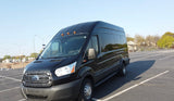 A black high-roof Ford Transit van, ideal for RV rental conversions, is parked facing forward in a large outdoor lot.