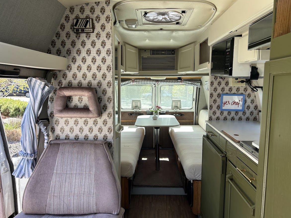  and comfy front seats.|Cozy RV rental interior with olive green kitchenette (microwave — photo 4