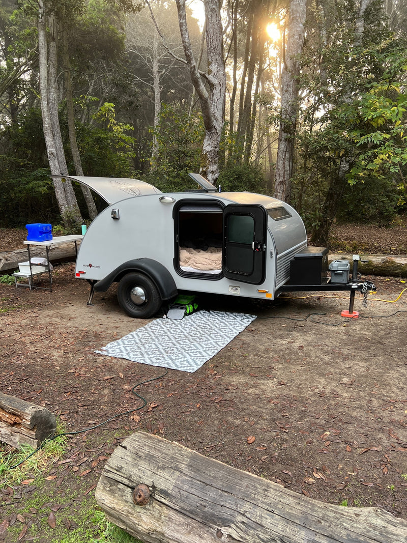  with a cozy bed visible inside.|Scenic RV rental trip! A teardrop camper by a golden autumn vineyard — photo 2