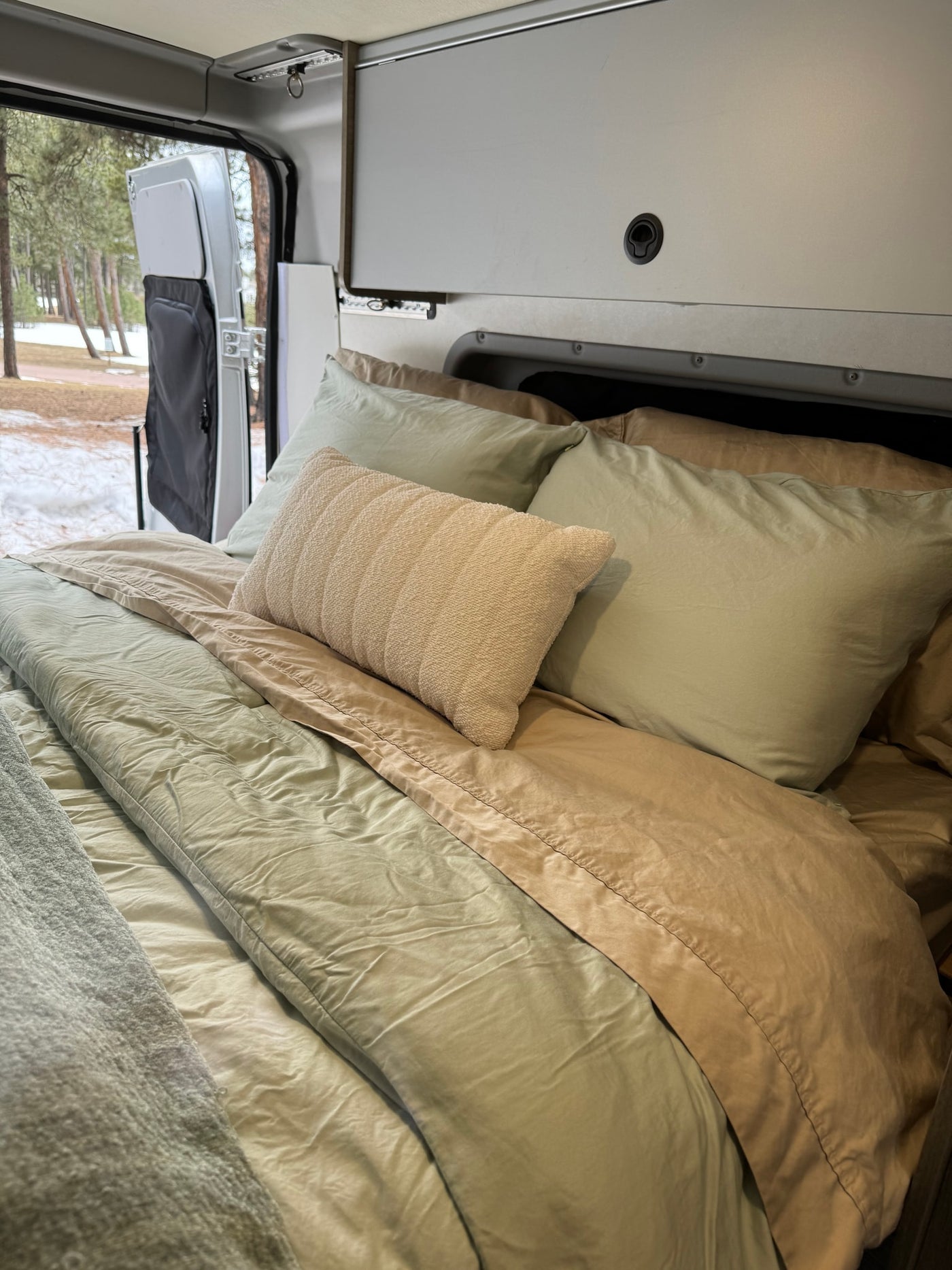  with a snowy winter forest view out the back.|Pop-top RV rental interior: overhead light — photo 16