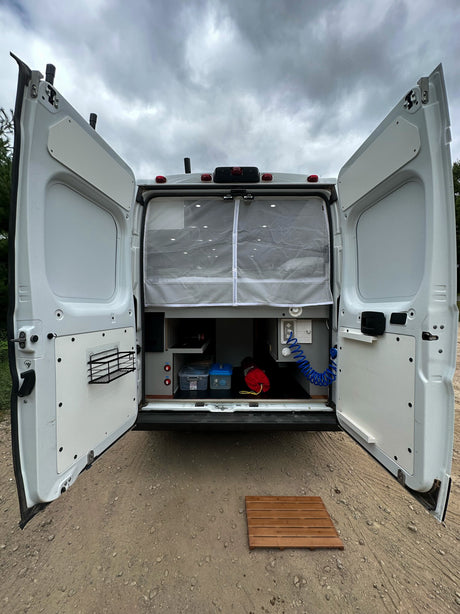 Ready for adventure! This rv rental's open back reveals custom storage, an outdoor shower, and a privacy curtain.