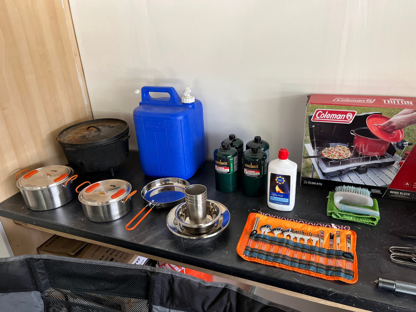 RV rental kitchen setup: Dutch ovens, Coleman stove, propane, water jug, and camping utensils for your trip. — photo 16