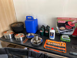 RV rental kitchen setup: Dutch ovens, Coleman stove, propane, water jug, and camping utensils for your trip.