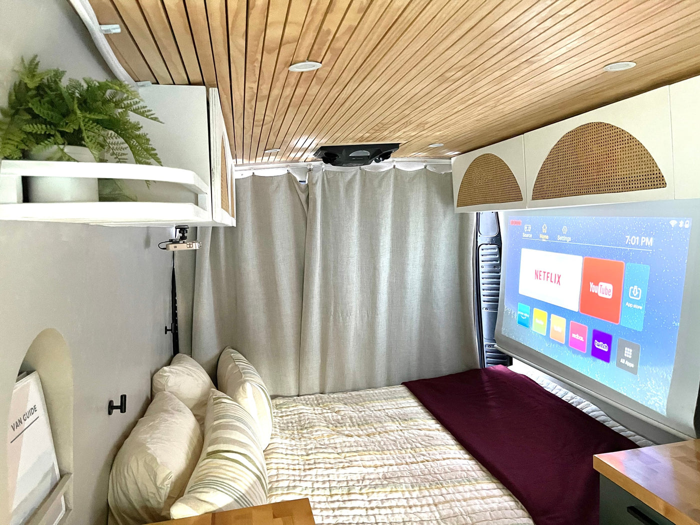 Inside a modern rv rental: a cozy sleeping area with a projector casting smart apps like Netflix & YouTube onto a screen. — photo 6