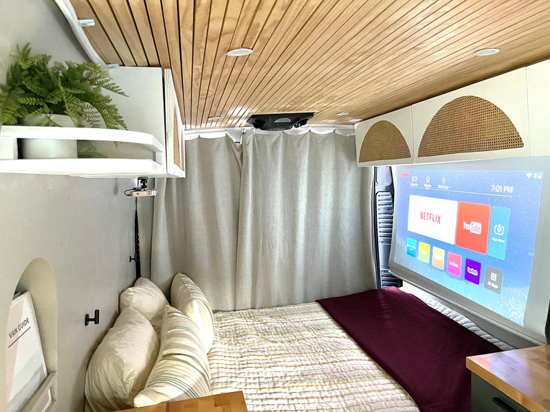 Inside a modern rv rental: a cozy sleeping area with a projector casting smart apps like Netflix & YouTube onto a screen. — photo 6