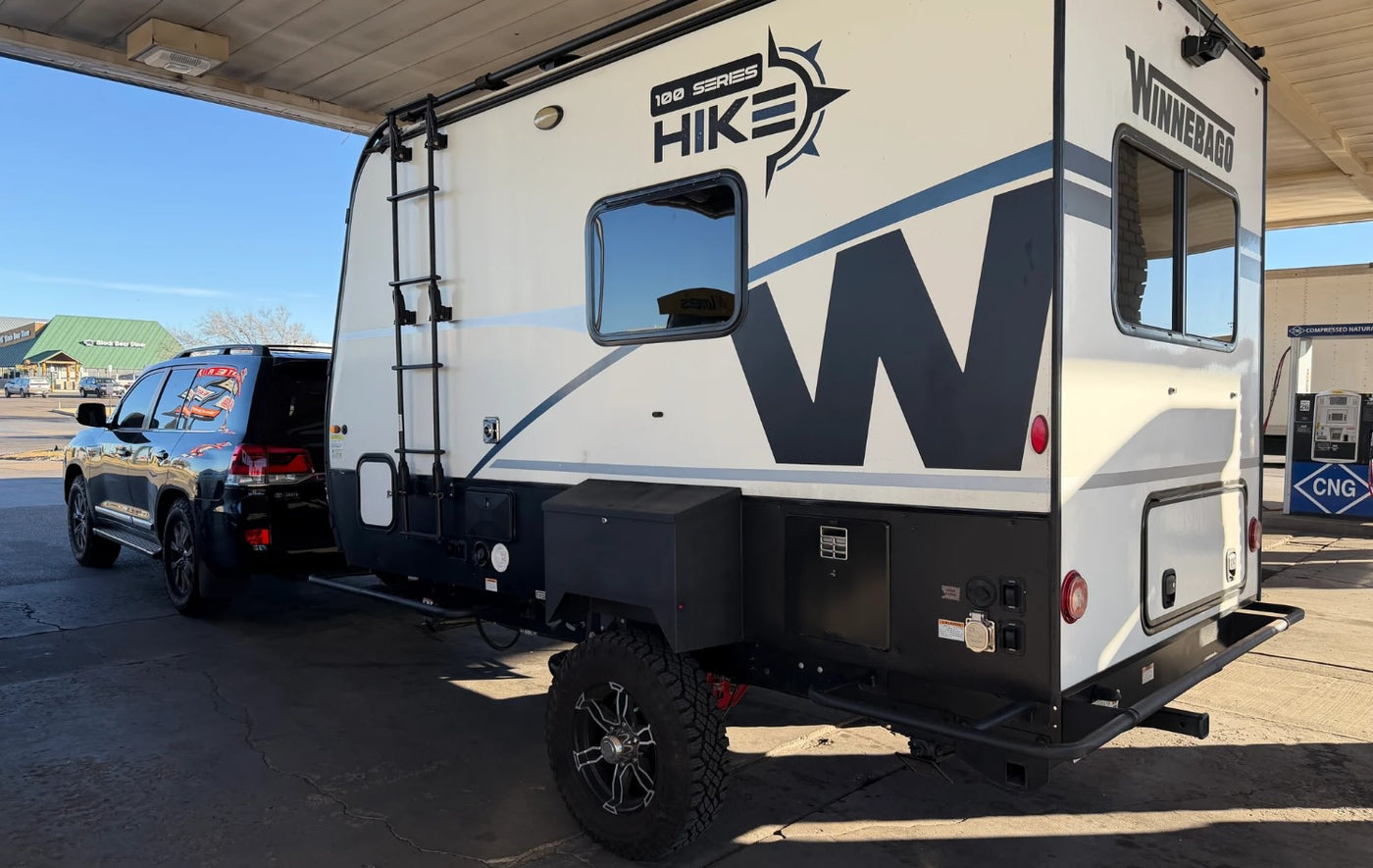  lit under a starry sky. Green and blue lights are visible among the clouds.|A Winnebago Hike RV rental