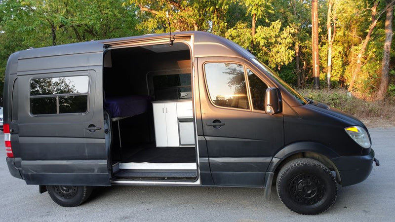  near houses & a kiosk.|RV rental camper van interior with compact kitchen — photo 2