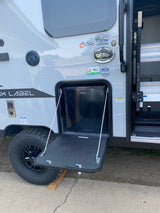 This rv rental offers outdoor convenience with an open exterior hatch revealing a Hotpoint mini-fridge and a pull-down table.