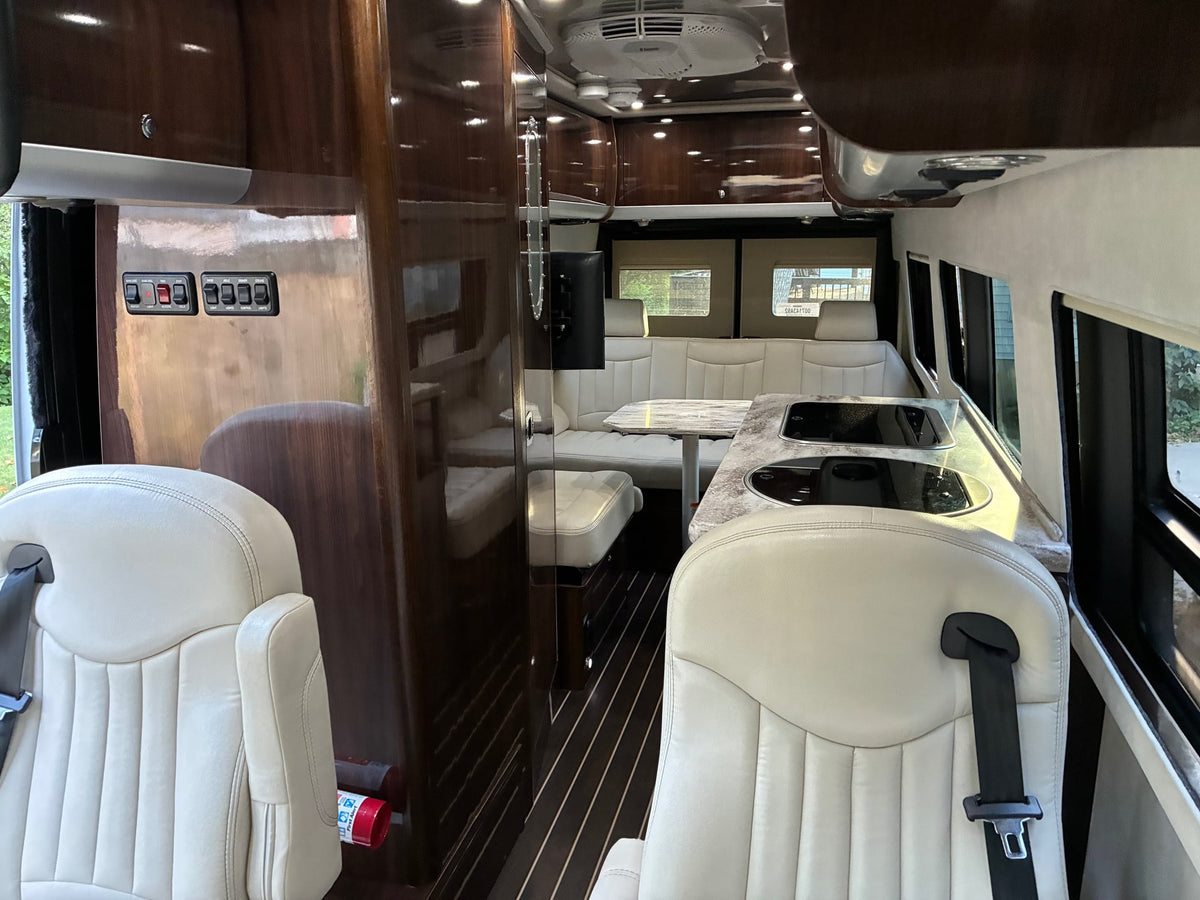  parked by a home with a patio setup.|Premium rv rental interior with cream leather seats — photo 2