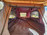 Comfortable rooftop tent interior with bedding visible, great for an RV rental camping adventure.