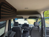 RV rental interior: View from the back into the spacious front cabin with dashboard, seats, and overhead storage.