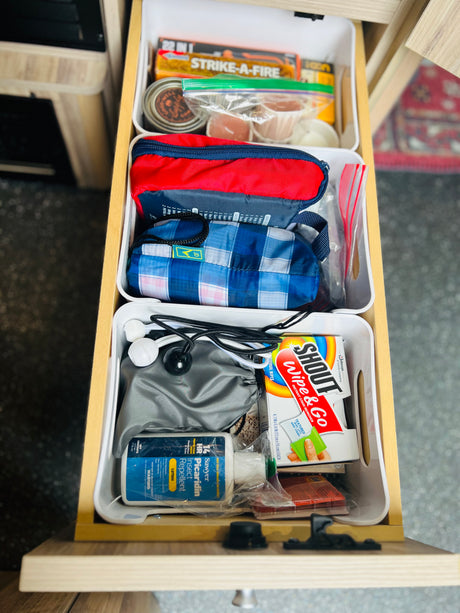 This organized RV rental drawer holds camping essentials: fire starters, bug spray, stain removers, and first-aid supplies.