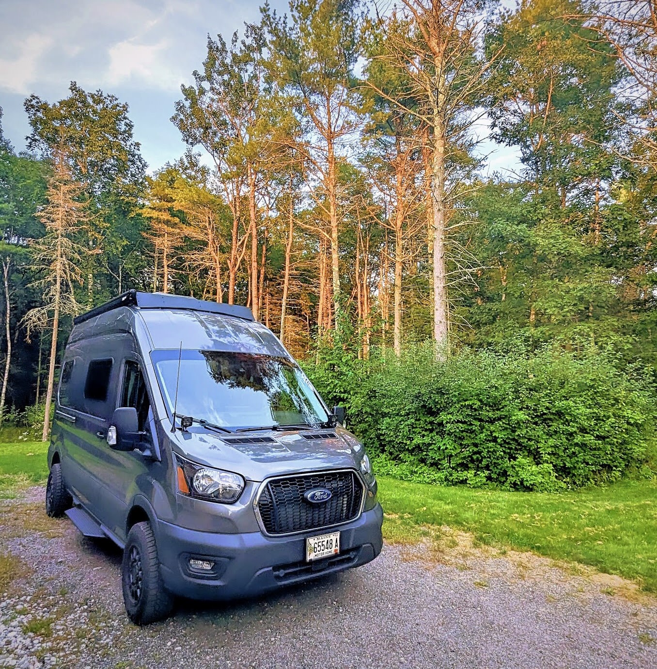  ideal for scenic trips.|Stylish grey camper van parked on green grass by a lake