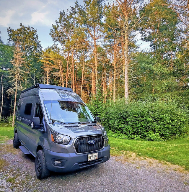  ideal for scenic trips.|Stylish grey camper van parked on green grass by a lake