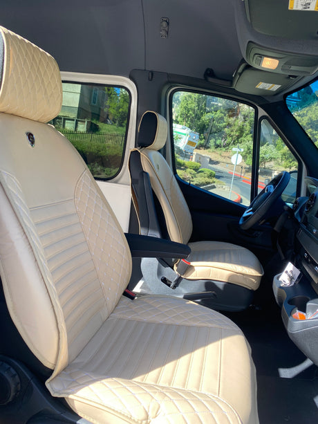 Inside this RV rental: plush, custom cream quilted front seats, offering comfort for your journey.