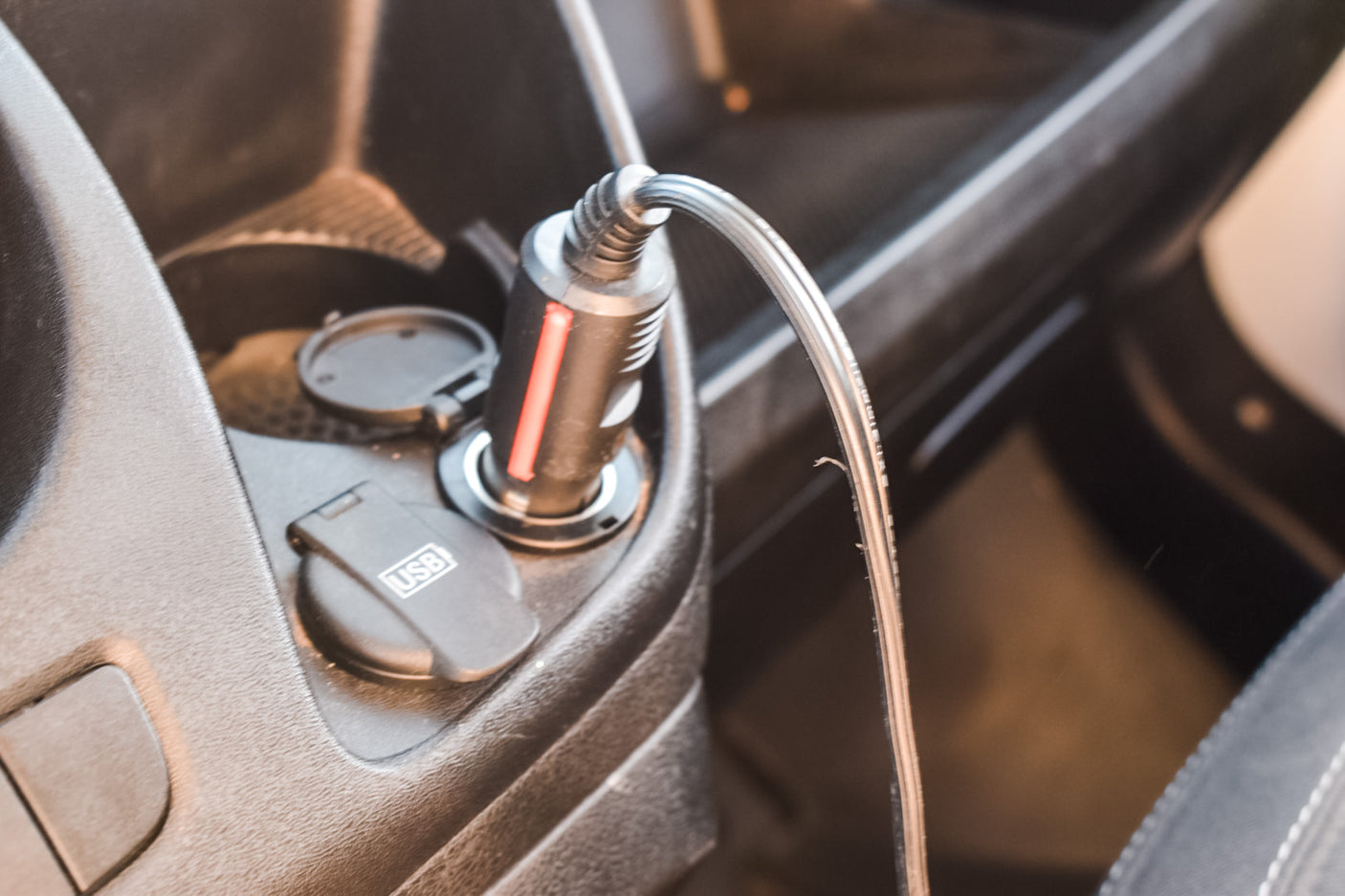 Charge devices in your RV rental. A car charger is plugged into a 12V outlet, with a USB cable, plus an integrated USB port.