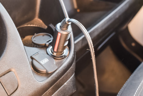 Charge devices in your RV rental. A car charger is plugged into a 12V outlet, with a USB cable, plus an integrated USB port.