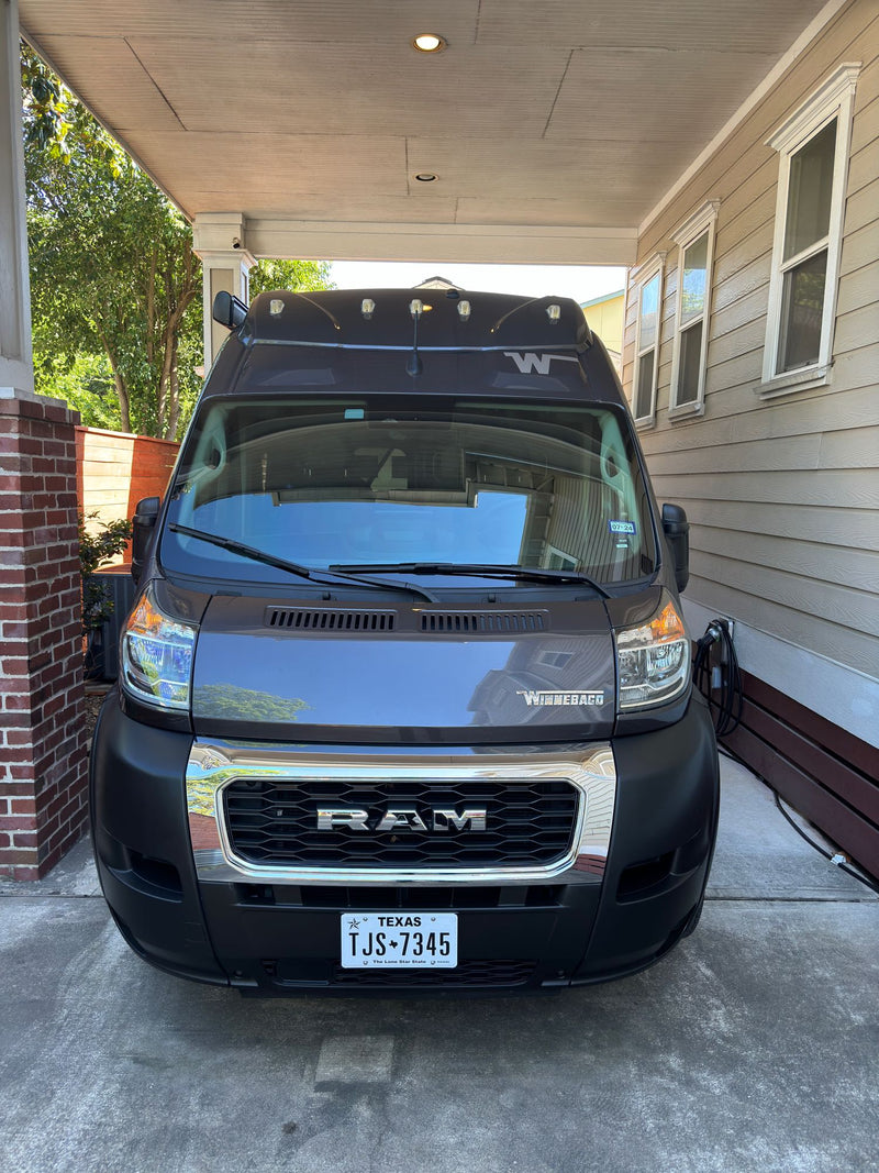  connected to power. Texas plate visible.|This dark grey Winnebago camper van is ready for your next rv rental adventure — photo 4