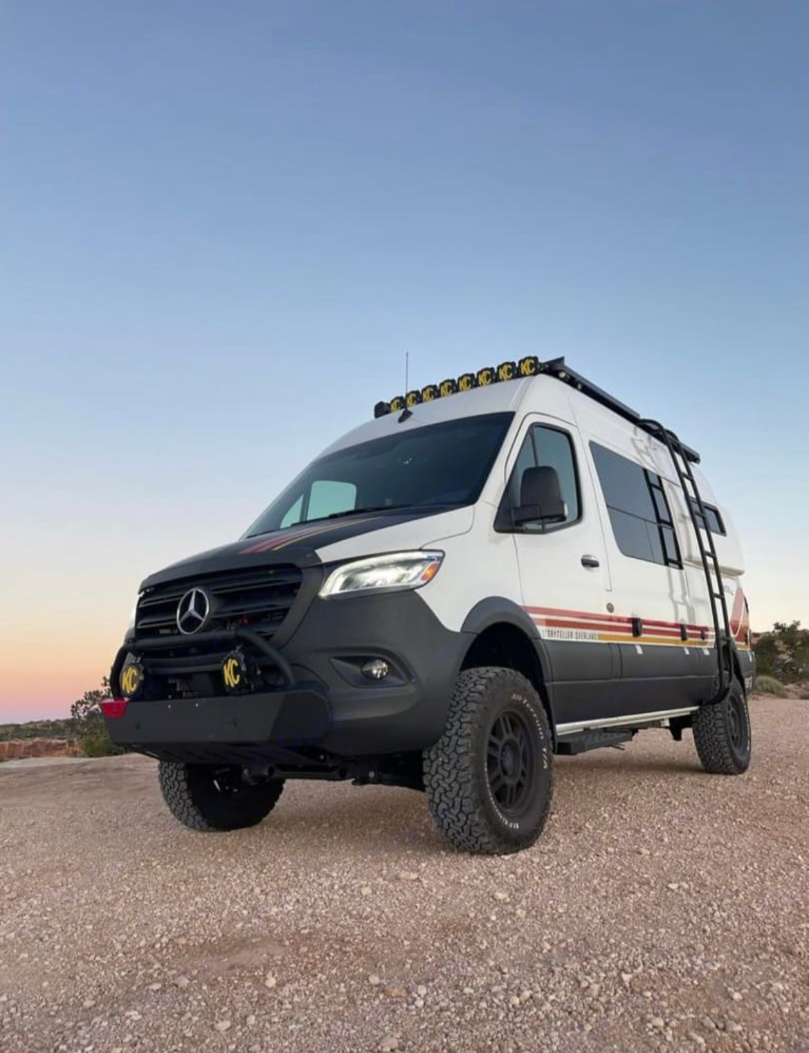 This lifted Mercedes Sprinter camper van, ideal for rv rental, features off-road tires & roof lights for remote travel.