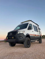 This lifted Mercedes Sprinter camper van, ideal for rv rental, features off-road tires & roof lights for remote travel.