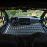 Inside an RV rental van, a Luno air mattress fills the front cab, creating a comfortable sleeping space perfect for van life adventures.