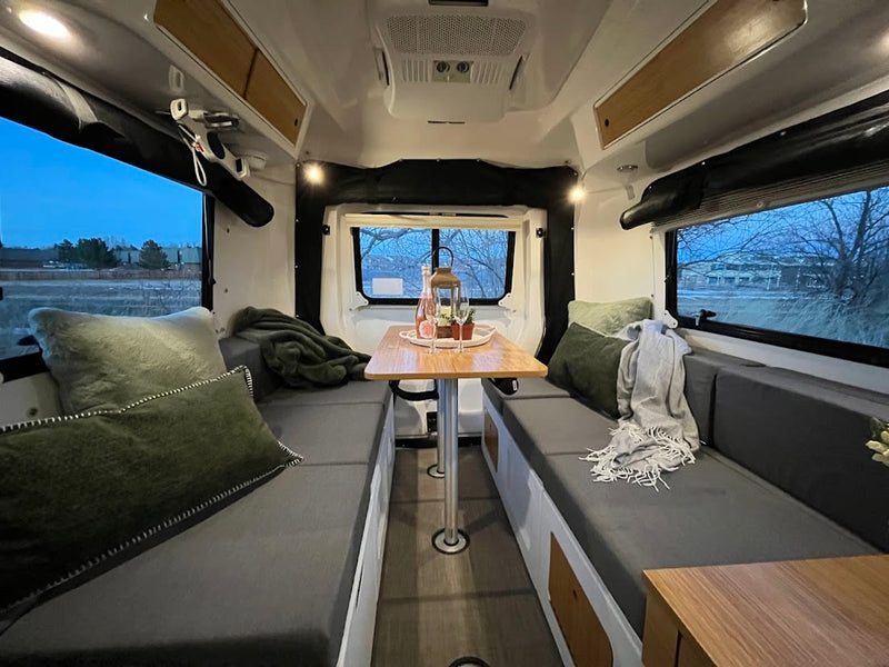  with an evening outdoor view.|This inviting rv rental interior features a grey sofa with green pillows — photo 4