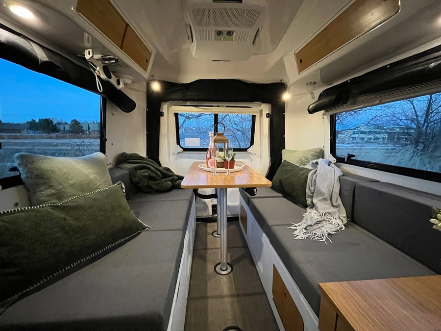  with an evening outdoor view.|This inviting rv rental interior features a grey sofa with green pillows