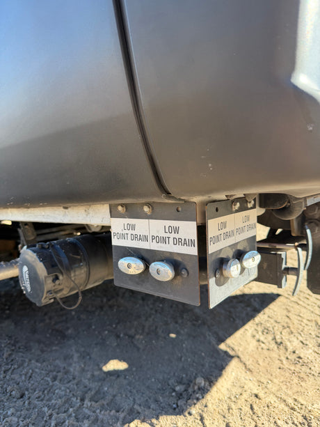Low point drains and waste water connection on an rv rental, vital for draining and winterizing the recreational vehicle's plumbing.