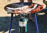 Delicious bacon sizzling on an outdoor griddle with propane. Perfect for your next RV rental camping trip!