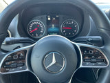 Close-up of a modern Mercedes-Benz RV rental dashboard, featuring the steering wheel with digital gauges and controls.